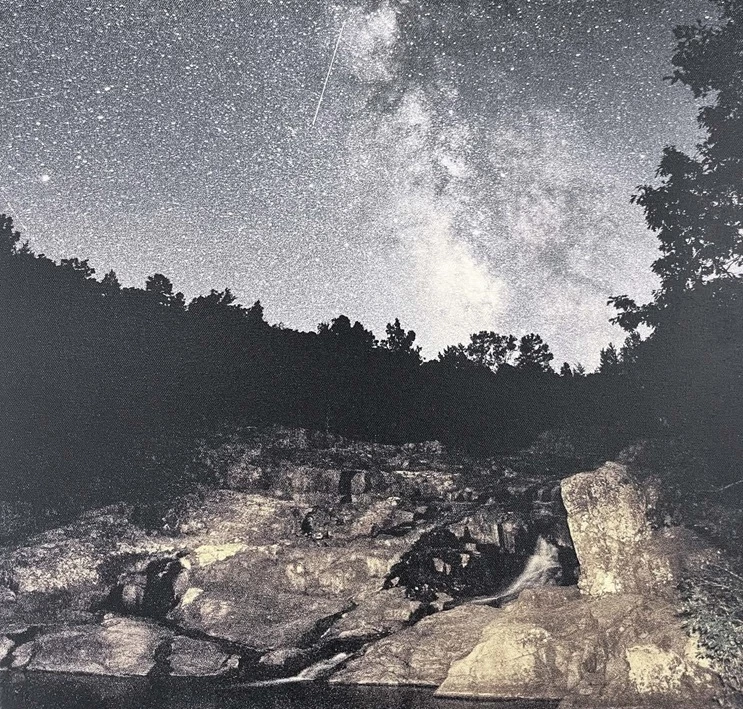 Night sky filled with stars over a rocky landscape